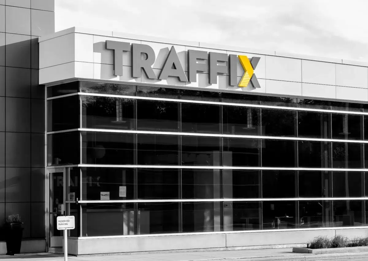 Black and white photo of a TRAFFIX sign on a building.